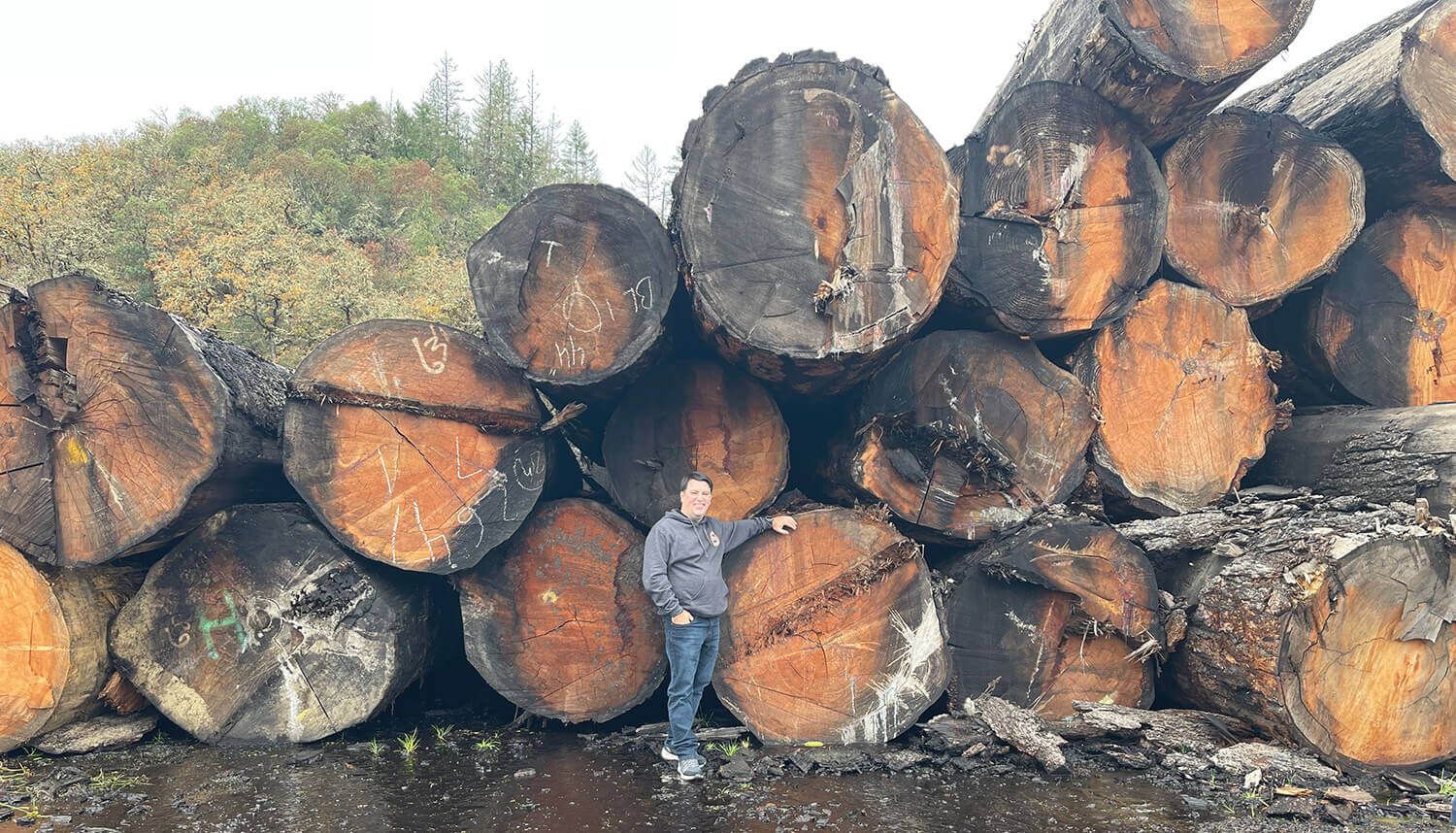 Man standing in front of a storage of timber